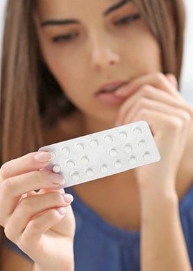 Eine Frau betrachtet eine Blisterpackung mit Tabletten in der Hand Fokus auf Medikament und Anwendung