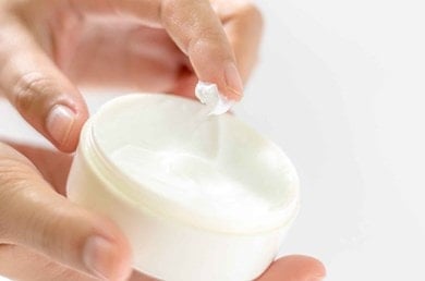 Finger entnehmen sanfte Creme aus Dose, steht für individuell abgestimmte Feuchtigkeitspflege